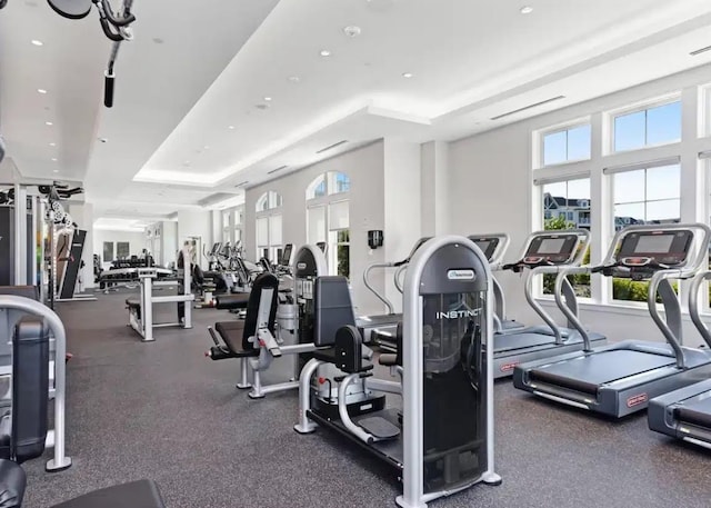 workout area featuring a raised ceiling and recessed lighting