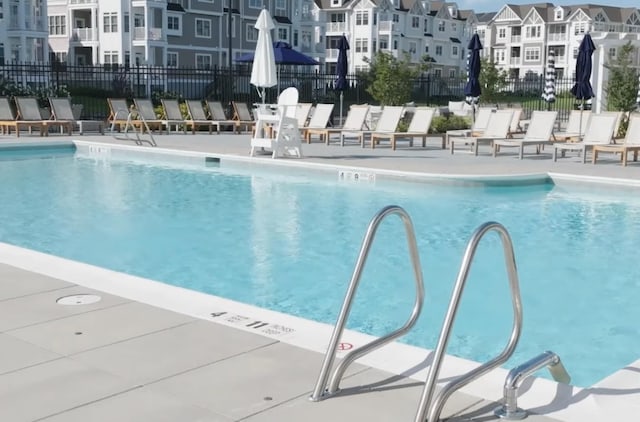 community pool featuring fence and a patio