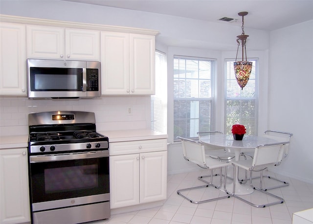 29 Madison Cir, Middle Island, NY 11953 - kitchen featuring appliances with stainless steel finishes, light countertops, baseboards, and decorative backsplash
