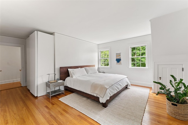 bedroom with light wood finished floors and baseboards