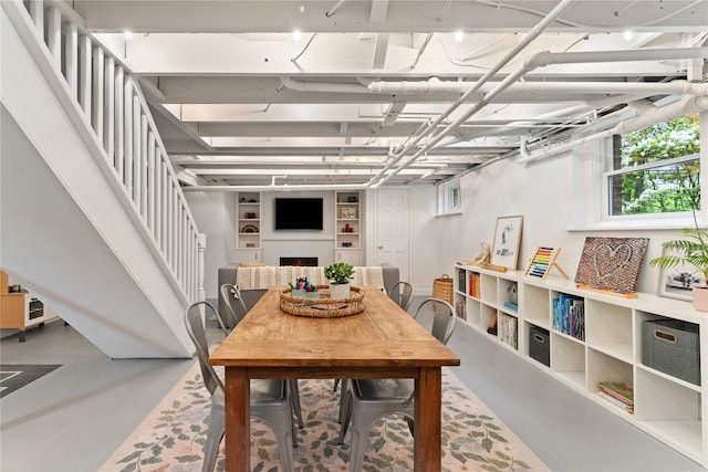 dining room featuring finished concrete floors and stairs