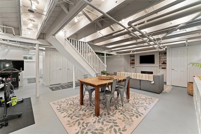 dining area featuring stairs and concrete flooring