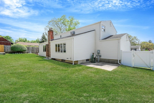 23 John St, Port Jefferson Station, NY 11776 - back of house featuring a gate, a chimney, and a patio
