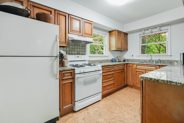 10 S Mountain Pond, Garrison, NY 10524 - kitchen featuring white appliances, under cabinet range hood, a sink, brown cabinets, and light stone counters