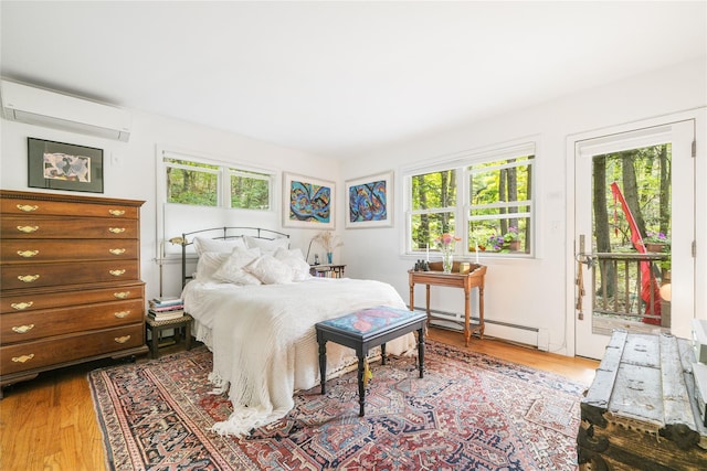 10 S Mountain Pond, Garrison, NY 10524 - bedroom featuring a wall mounted air conditioner, a baseboard heating unit, wood finished floors, and access to exterior