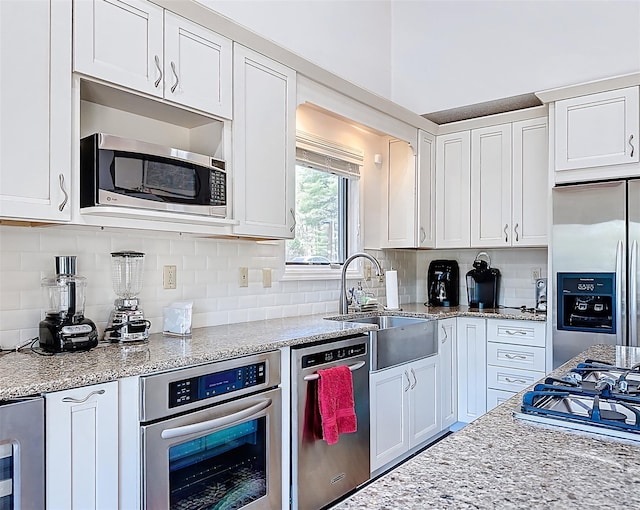 5 Water Lilly Ln, Monticello, NY 12701 - kitchen with stainless steel appliances, a sink, white cabinetry, and backsplash
