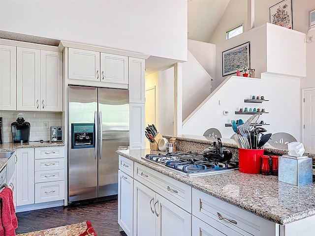 5 Water Lilly Ln, Monticello, NY 12701 - kitchen featuring stainless steel fridge, gas stovetop, dark wood-type flooring, white cabinets, and high vaulted ceiling