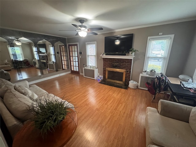 702 Tower Ct, Uniondale, NY 11553 - living area with ceiling fan, a fireplace, light wood-style floors, arched walkways, and ornamental molding