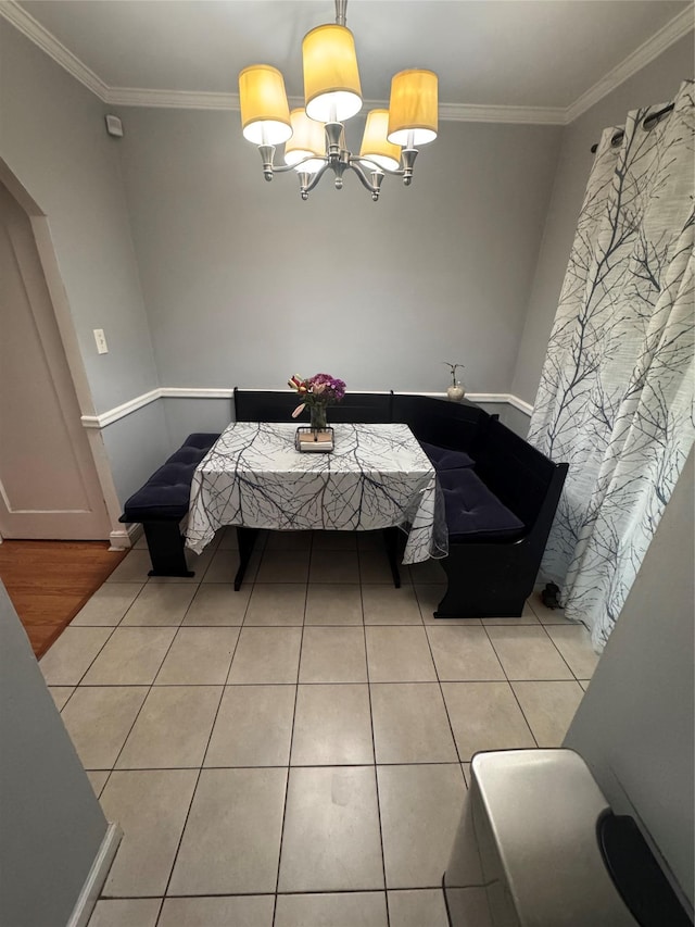 702 Tower Ct, Uniondale, NY 11553 - dining area with crown molding, light tile patterned floors, a chandelier, and baseboards