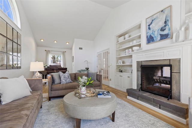 2 Robert Crisfield Pl, Rye, NY 10580 - living area featuring light wood finished floors, high vaulted ceiling, a fireplace with raised hearth, built in features, and recessed lighting
