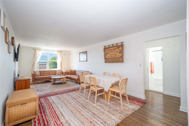 dining area featuring wood finished floors, cooling unit, and baseboards