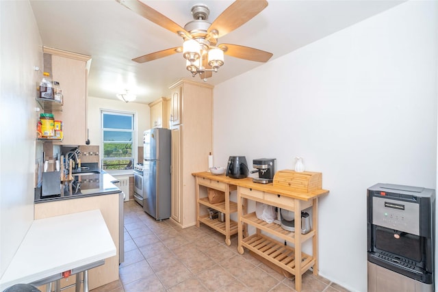 kitchen with freestanding refrigerator, a sink, light tile patterned flooring, a ceiling fan, and light brown cabinets