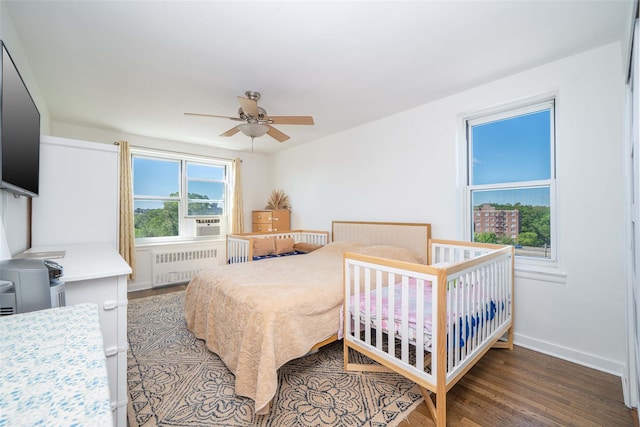 bedroom featuring radiator heating unit, wood finished floors, baseboards, and ceiling fan