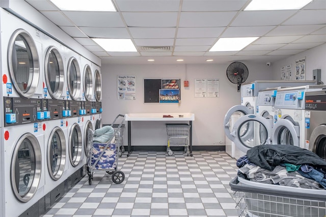 communal laundry room with tile patterned floors, estacked washer and dryer, and washer and clothes dryer