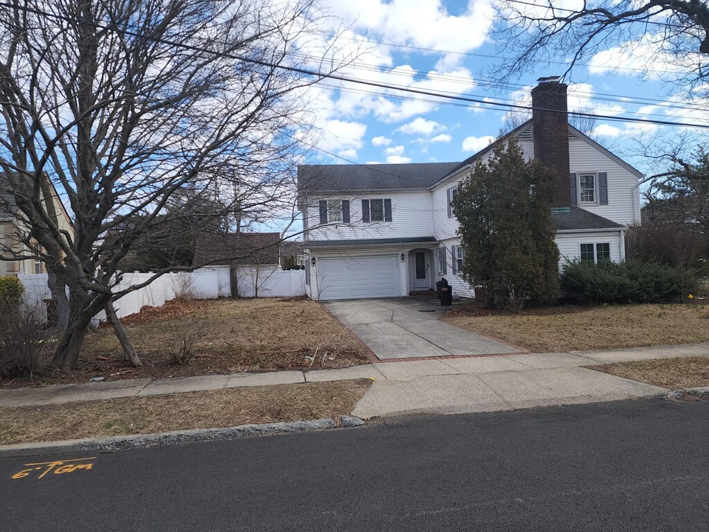 15 Mckenna Ave, North Baldwin, NY 11510 - traditional-style home featuring fence, a chimney, driveway, and a garage