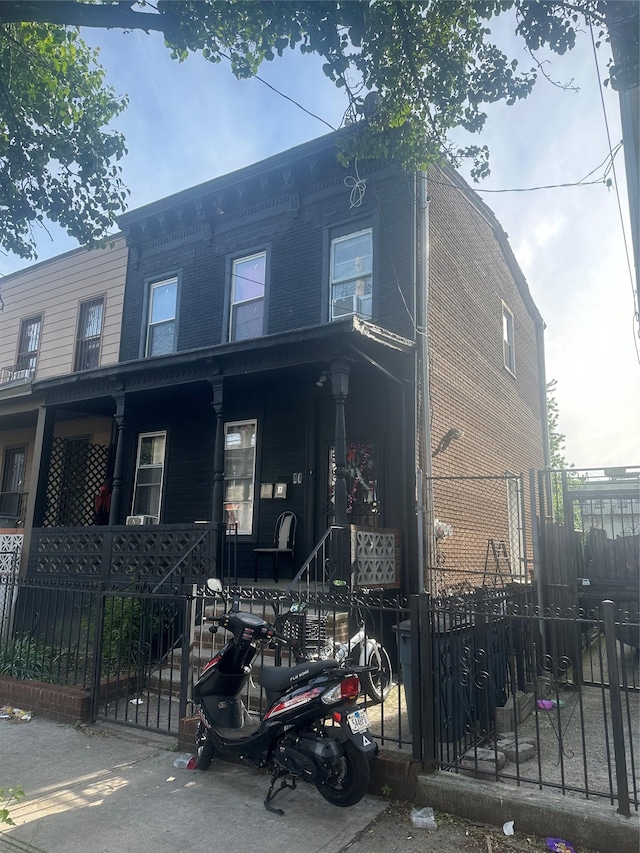 90 Wyona St, Brooklyn, NY 11207 - view of front facade featuring covered porch and a fenced front yard
