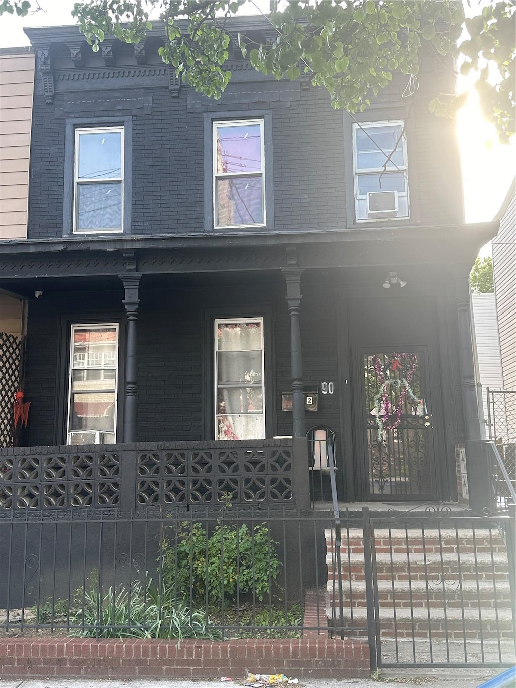 90 Wyona St, Brooklyn, NY 11207 - view of front of house featuring covered porch and a fenced front yard