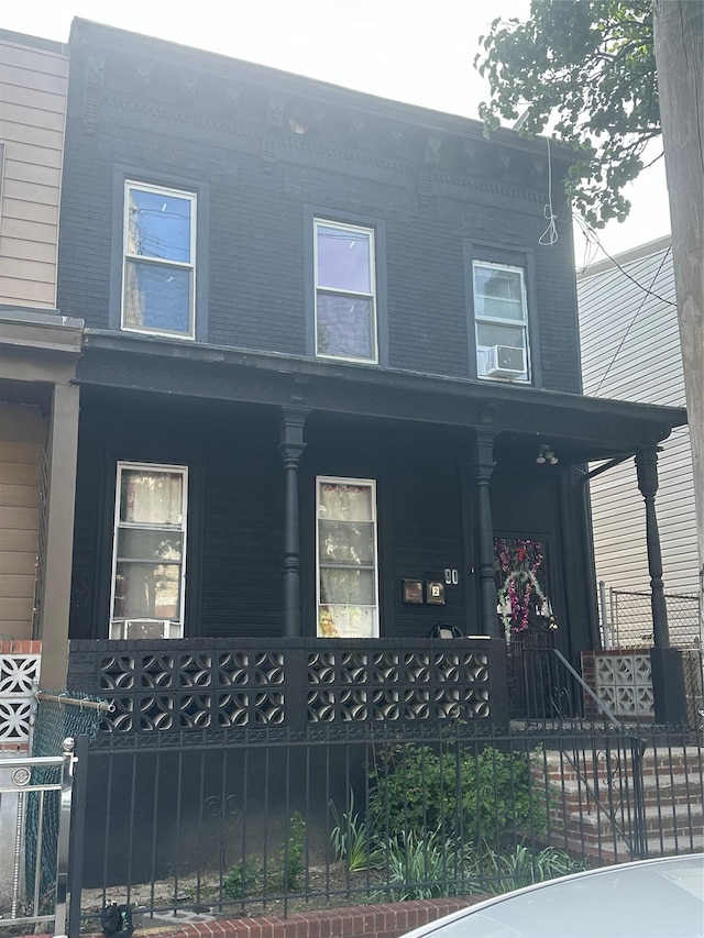 90 Wyona St, Brooklyn, NY 11207 - view of front facade featuring covered porch, a fenced front yard, and central AC