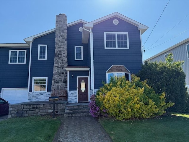 view of front facade with a chimney and stone siding