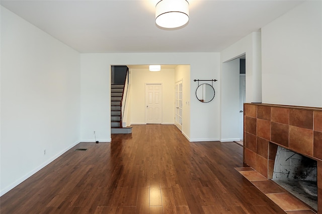 114 Frankel Blvd, Merrick, NY 11566 - empty room with dark wood-style floors, baseboards, stairway, and a tile fireplace
