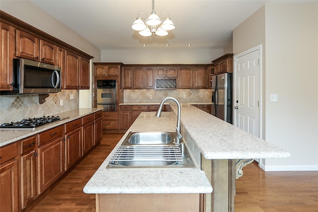 114 Frankel Blvd, Merrick, NY 11566 - kitchen featuring appliances with stainless steel finishes, a sink, a large island with sink, a chandelier, and a warming drawer