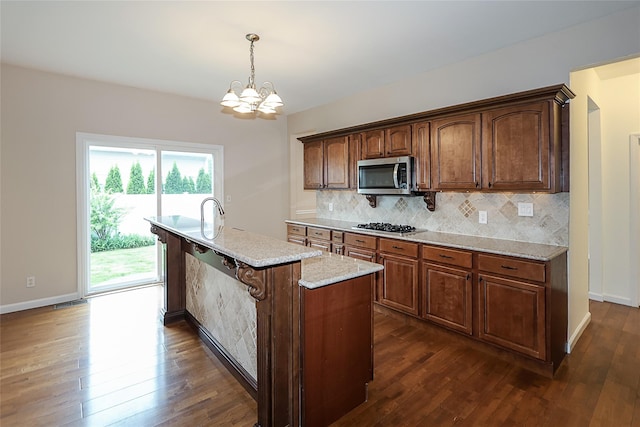 114 Frankel Blvd, Merrick, NY 11566 - kitchen with stainless steel appliances, a chandelier, tasteful backsplash, dark wood-type flooring, and baseboards