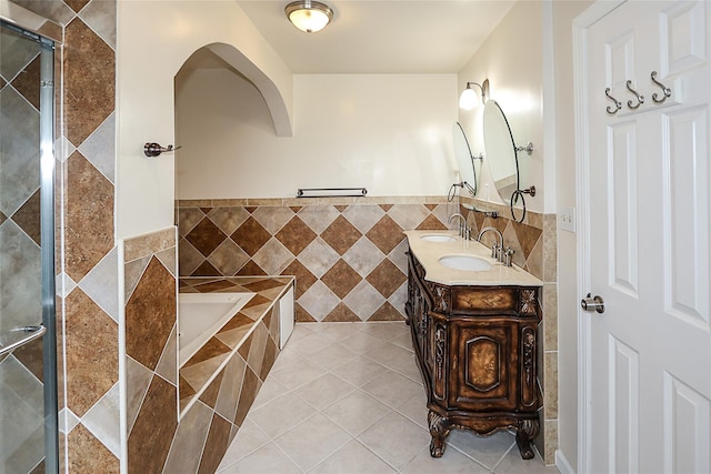 114 Frankel Blvd, Merrick, NY 11566 - bathroom with tile walls, vanity, a garden tub, tile patterned flooring, and tiled shower