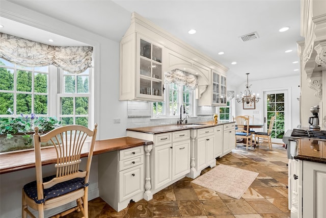 17 Byron Ln, Larchmont, NY 10538 - kitchen with tasteful backsplash, a sink, a chandelier, recessed lighting, and glass insert cabinets