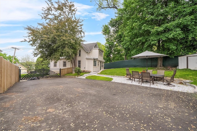 1219 Maple Ave, Peekskill, NY 10566 - view of yard featuring a gate, an outbuilding, a storage shed, outdoor dining space, and a patio