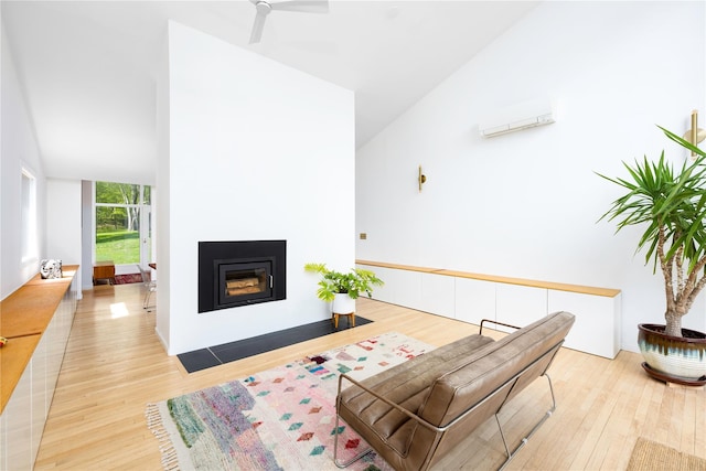 82 Moadock Rd, Millerton, NY 12546 - living room featuring a wall mounted AC, wood finished floors, a glass covered fireplace, a ceiling fan, and lofted ceiling