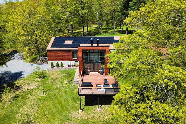 82 Moadock Rd, Millerton, NY 12546 - rear view of house with roof mounted solar panels, a deck, and a view of trees