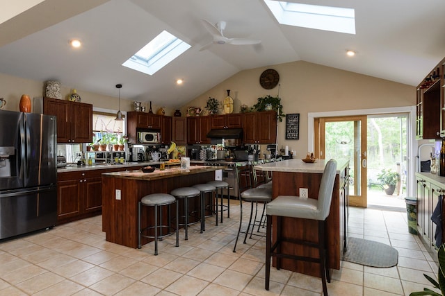 11 Crescent St, Mastic, NY 11950 - kitchen featuring black fridge with ice dispenser, a skylight, a kitchen bar, a ceiling fan, and light tile patterned floors