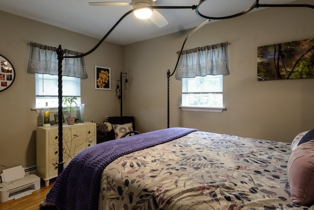 11 Crescent St, Mastic, NY 11950 - bedroom with multiple windows, light wood-style flooring, ceiling fan, and a baseboard heating unit