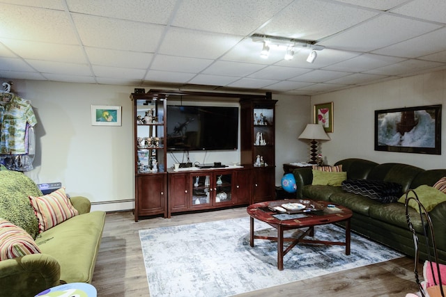 11 Crescent St, Mastic, NY 11950 - living room with rail lighting, baseboard heating, wood finished floors, and a paneled ceiling