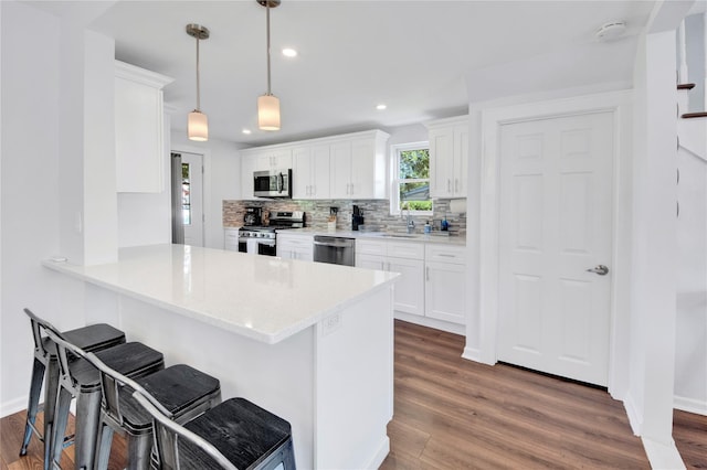26 Alta Dr, Mount Vernon, NY 10552 - kitchen with stainless steel appliances, a kitchen bar, decorative backsplash, white cabinetry, and recessed lighting