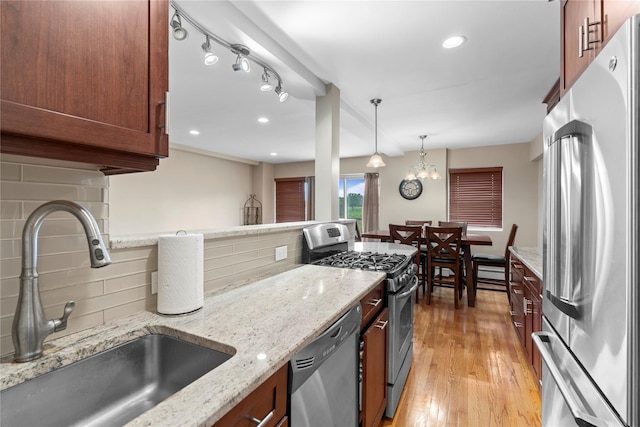 80 E Hartsdale Ave Unit 520, Hartsdale, NY 10530 - kitchen featuring appliances with stainless steel finishes, a sink, tasteful backsplash, light wood-style floors, and hanging light fixtures