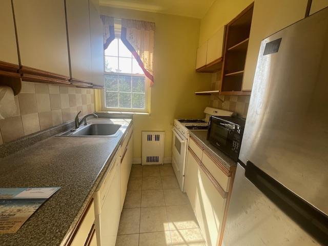 230 Central Ave Unit 2-H, Lawrence, NY 11559 - kitchen featuring freestanding refrigerator, a sink, gas range gas stove, radiator, and open shelves