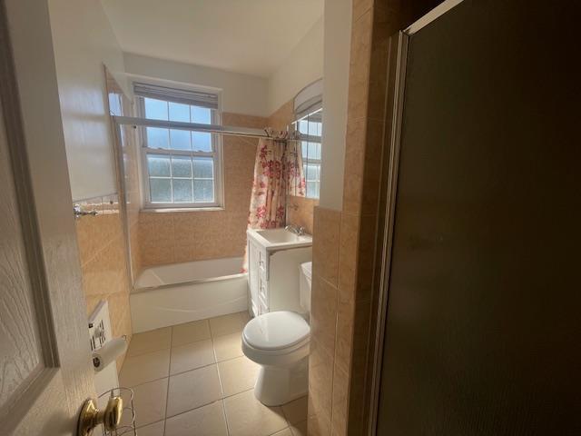 230 Central Ave Unit 2-H, Lawrence, NY 11559 - full bath with tile patterned floors, toilet, and shower / bath combination with glass door