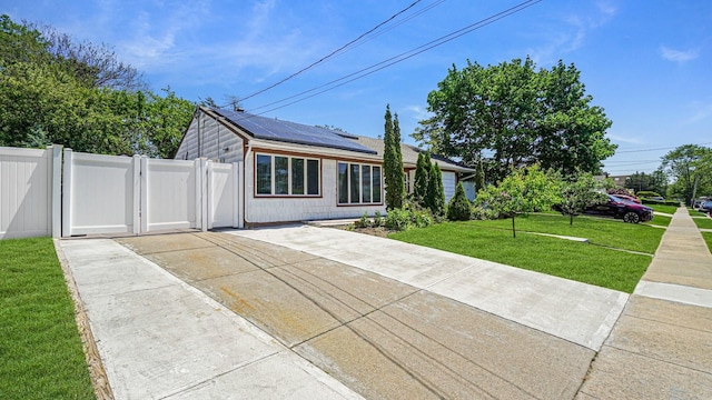 871 Val Park Ave, Valley Stream, NY 11580 - view of front of property featuring roof mounted solar panels, concrete driveway, and a gate