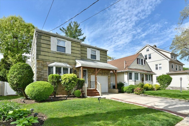 186 E Chester St, Valley Stream, NY 11580 - view of front facade featuring stone siding, a garage, a front lawn, and driveway