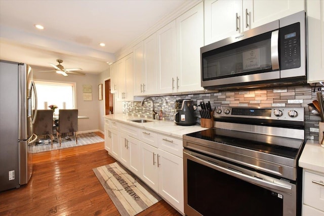 186 E Chester St, Valley Stream, NY 11580 - kitchen featuring appliances with stainless steel finishes, a sink, white cabinets, backsplash, and a ceiling fan
