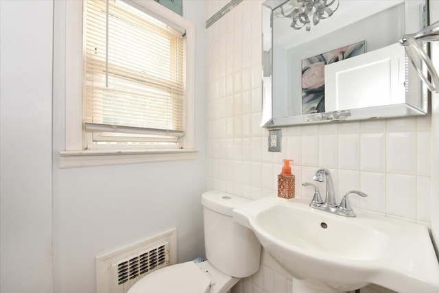 186 E Chester St, Valley Stream, NY 11580 - half bathroom featuring a sink, toilet, tile walls, and tasteful backsplash