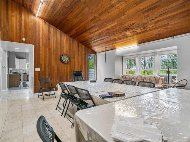 36 Starr Ave, Monticello, NY 12701 - dining area featuring wood walls, wood ceiling, high vaulted ceiling, and light tile patterned flooring