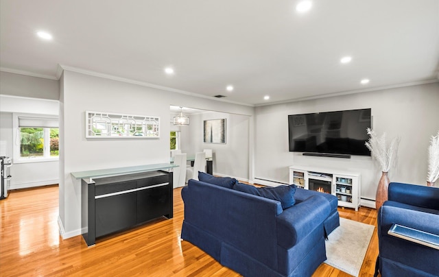 19 Walter Ct, Commack, NY 11725 - living room featuring crown molding, recessed lighting, a baseboard heating unit, light wood finished floors, and a warm lit fireplace