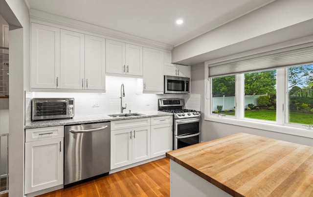 19 Walter Ct, Commack, NY 11725 - kitchen with appliances with stainless steel finishes, a sink, wood counters, tasteful backsplash, and white cabinetry
