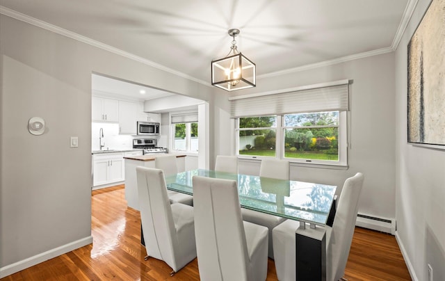 19 Walter Ct, Commack, NY 11725 - dining area featuring baseboard heating, a chandelier, crown molding, baseboards, and light wood-type flooring