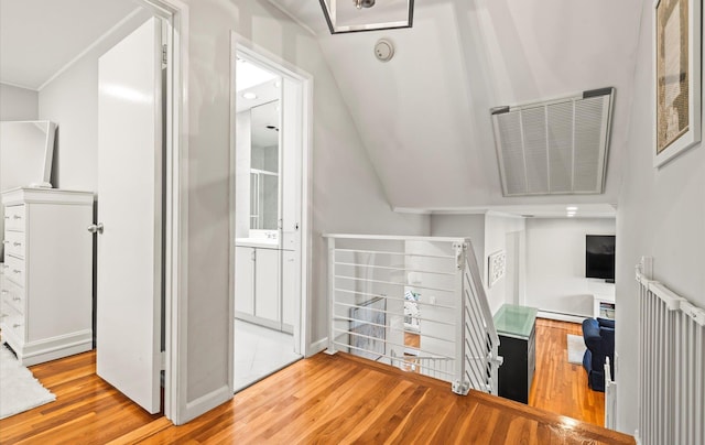 19 Walter Ct, Commack, NY 11725 - stairs featuring wood finished floors, a baseboard radiator, vaulted ceiling, and baseboards