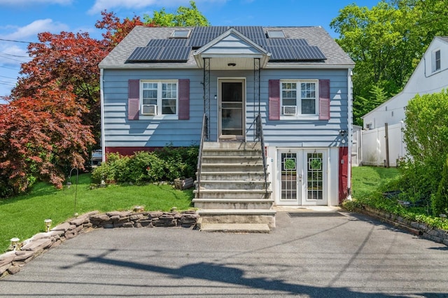 722 Shenandoah Ave, Peekskill, NY 10566 - view of front facade featuring roof mounted solar panels, a shingled roof, and french doors