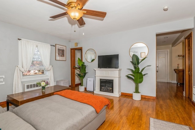 722 Shenandoah Ave, Peekskill, NY 10566 - bedroom with radiator heating unit, a glass covered fireplace, hardwood / wood-style floors, baseboards, and a ceiling fan