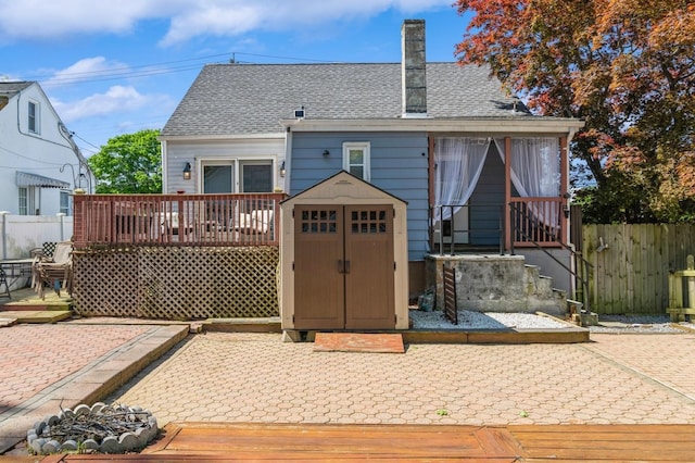 722 Shenandoah Ave, Peekskill, NY 10566 - back of house featuring fence, a storage unit, a shingled roof, an outdoor structure, and a chimney